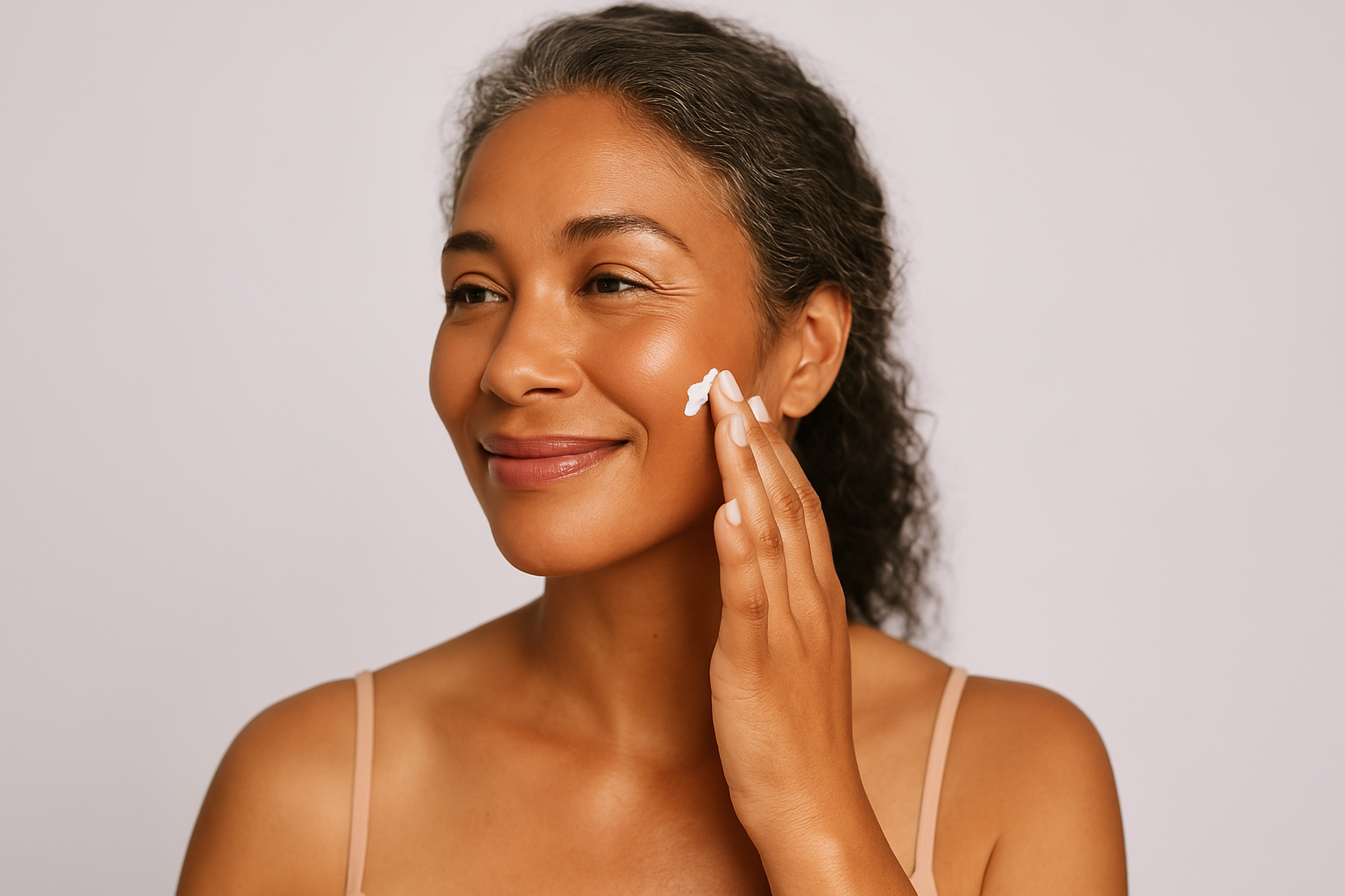 Flat lay of anti-aging skincare products and botanical ingredients on a soft beige background