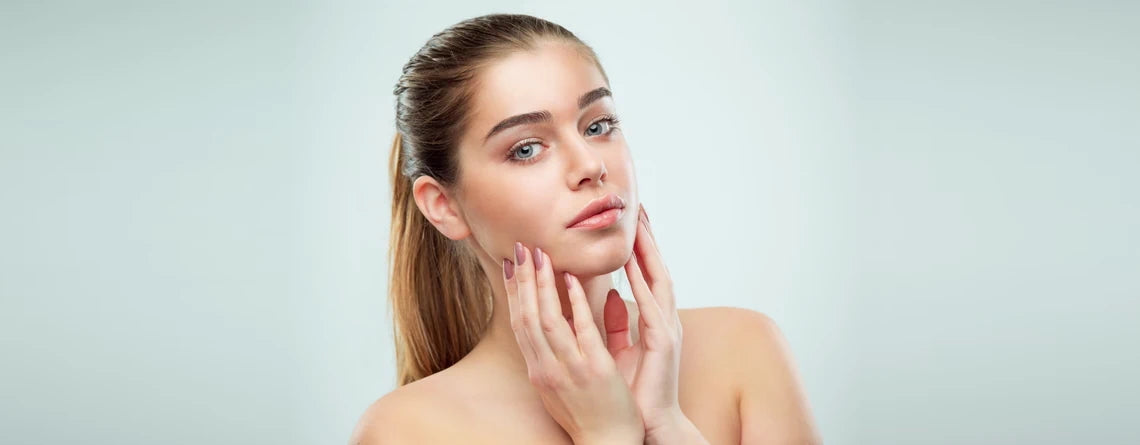 Young woman with hydrated skin gently touching her face, representing dry skin care results
