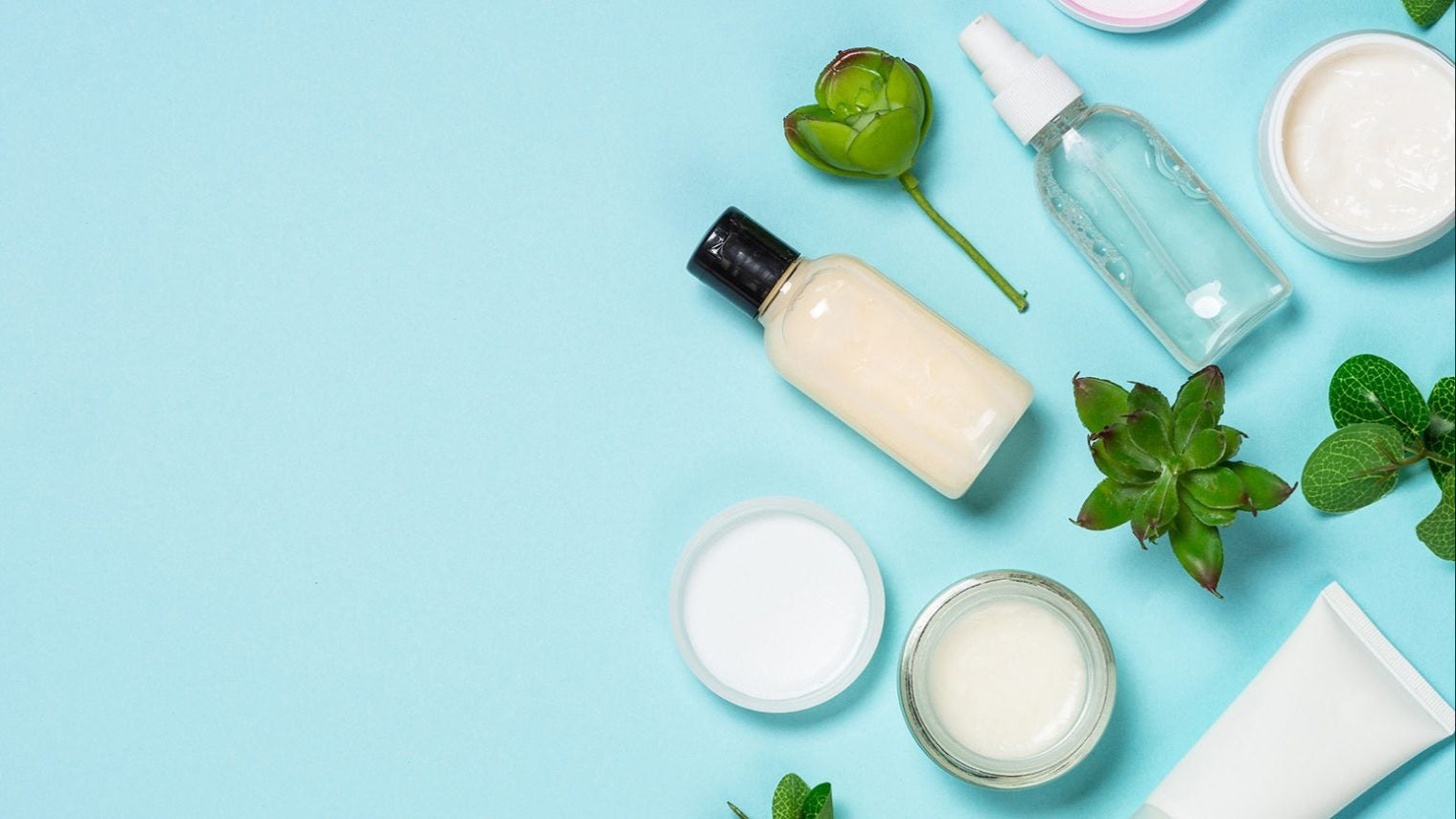 Flat lay of skincare products and natural ingredients on a blue background, representing hydration, balance, and oil control for oily skin. Featured on Allana Davis Studio.